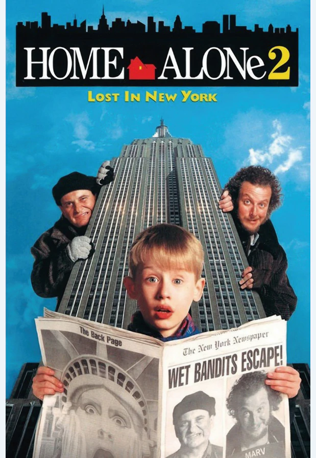 A young boy reading a newspaper in front of the Empire State Building with two men looking from behind the building. 